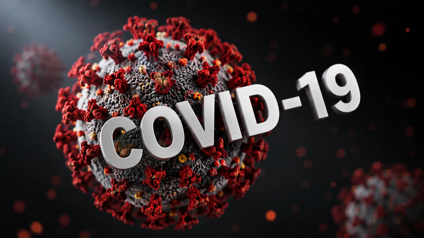 3D illustration of a COVID-19 virus particle with red spike proteins and the text “COVID-19,” representing research into viral reactivation during and after COVID-19.